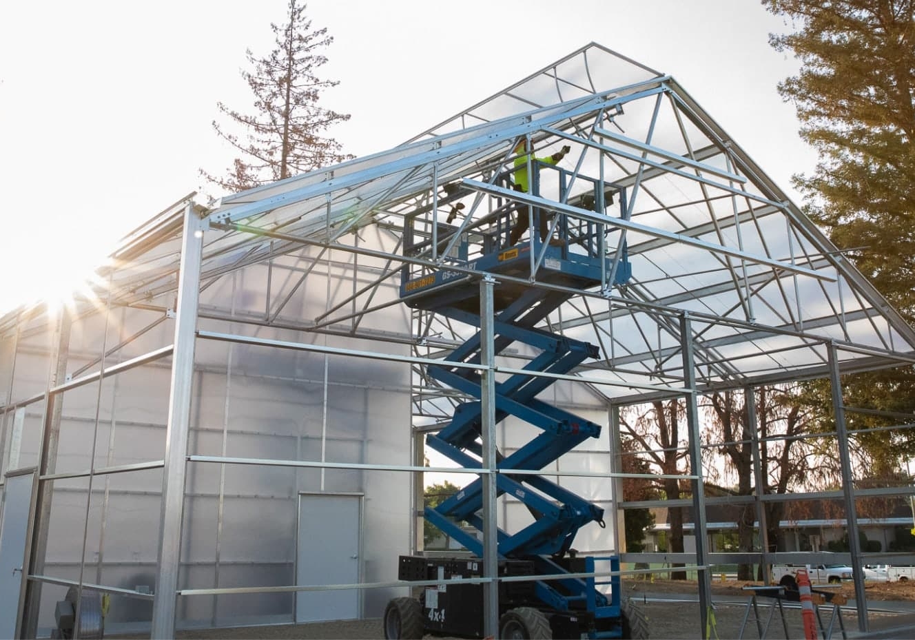 design build cta Greenhouse under construction with rising sun behind